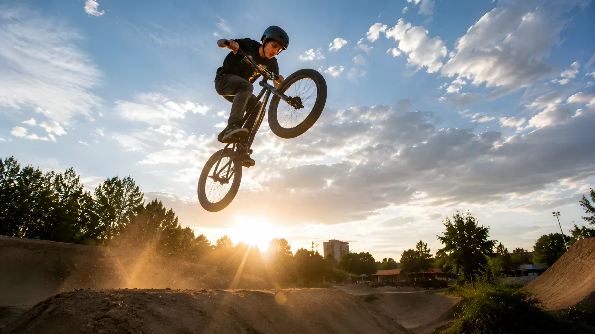 BMX-Fahrer springt bei Sonnenuntergang über Dirt-Jump