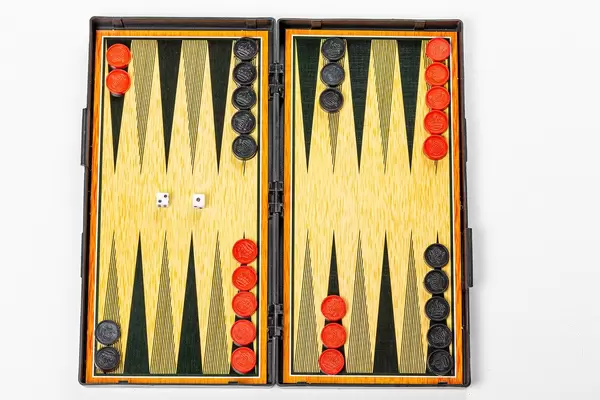 Board for playing backgammon with pieces and dice on a white background. Top view (Flip 2019)
