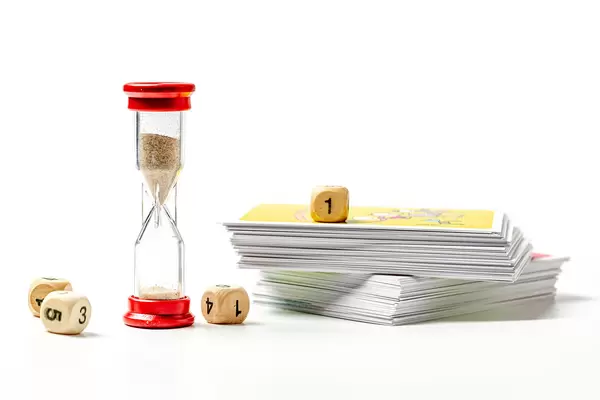 Board game concept - cards with questions, hourglass and cubes with numbers on a white background