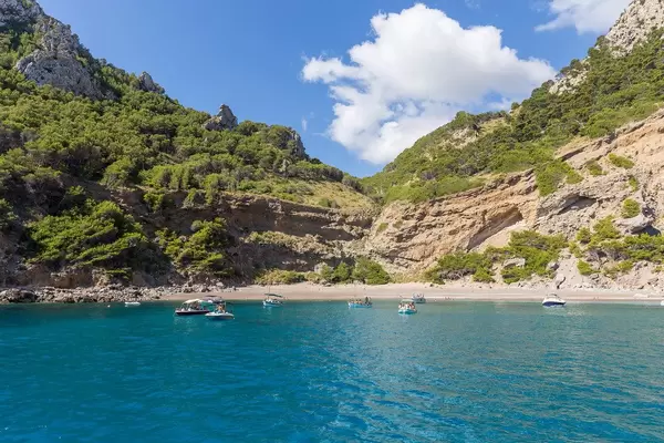 Boats in front of Platja des Coll Baix beach near Punta des Gavinot on Mallorca. View from the sea