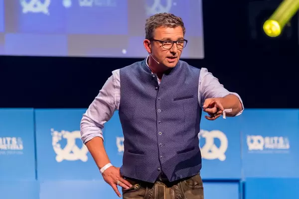 Body language and public speaking: Austrian actor Hans Sigl points his finger at the audience during a passionate speech at the Bits & Pretzels conference