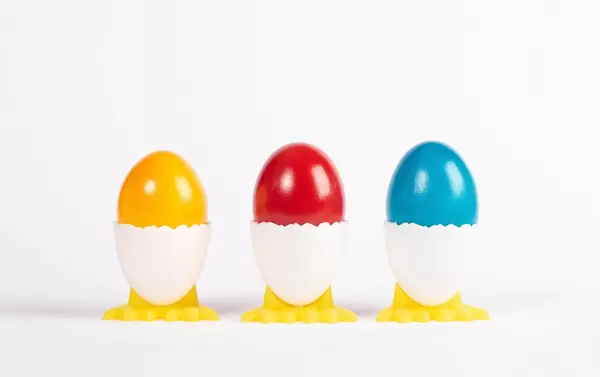 Boiled eggs in holders on white background