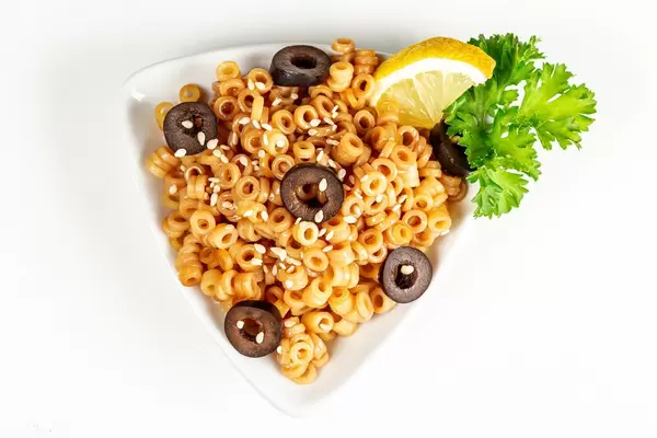 Boiled pasta with chunks of black olives, soy sauce and sesame seeds