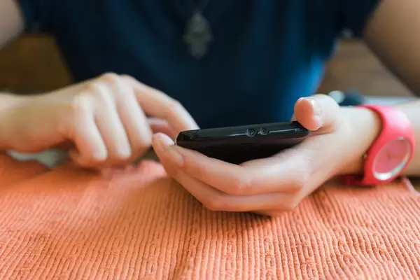 Bokeh Photo of a Person holding a black Smartphone