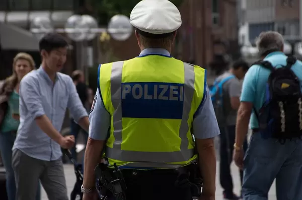 Bokeh Photo of German Police Officer in yellow vest walking in a City