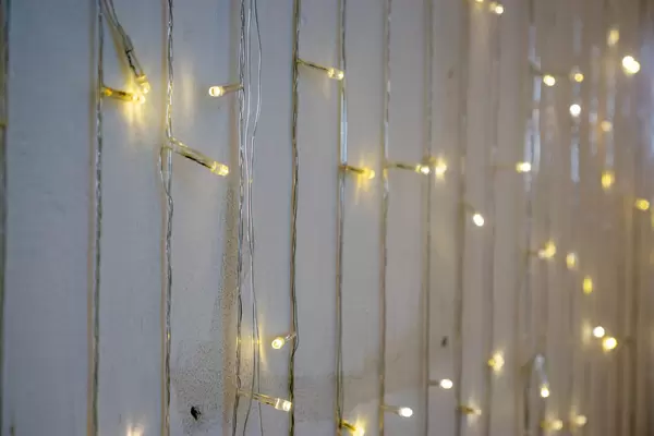 Bokeh Photo of String Lights hanging down a White Wall in a Cafe
