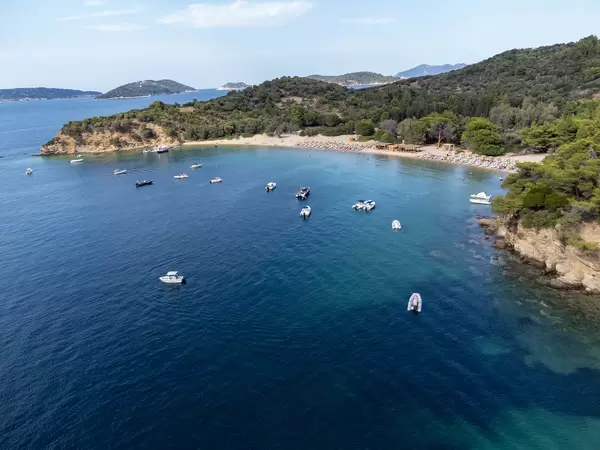 Boote erreichen den Sandstrand Tsoungrias auf der kleinen Insel bei Skiathos. Luftbild