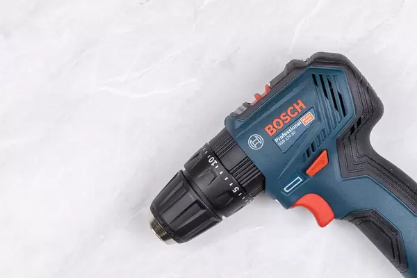 Bosch drill above white table with copy space