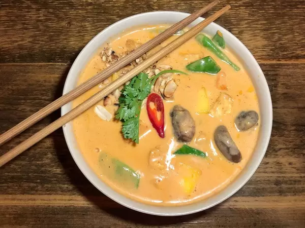 Bowl of vegan Can Xoai with tofu, vegetables, shiitake mushrooms and chili in coconut mango curry