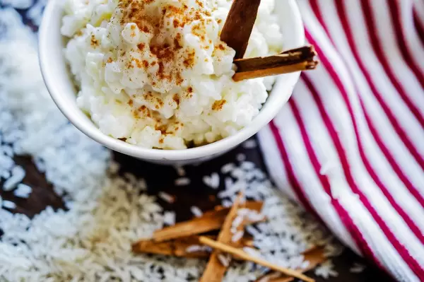 Bowl with rice pudding over wood table