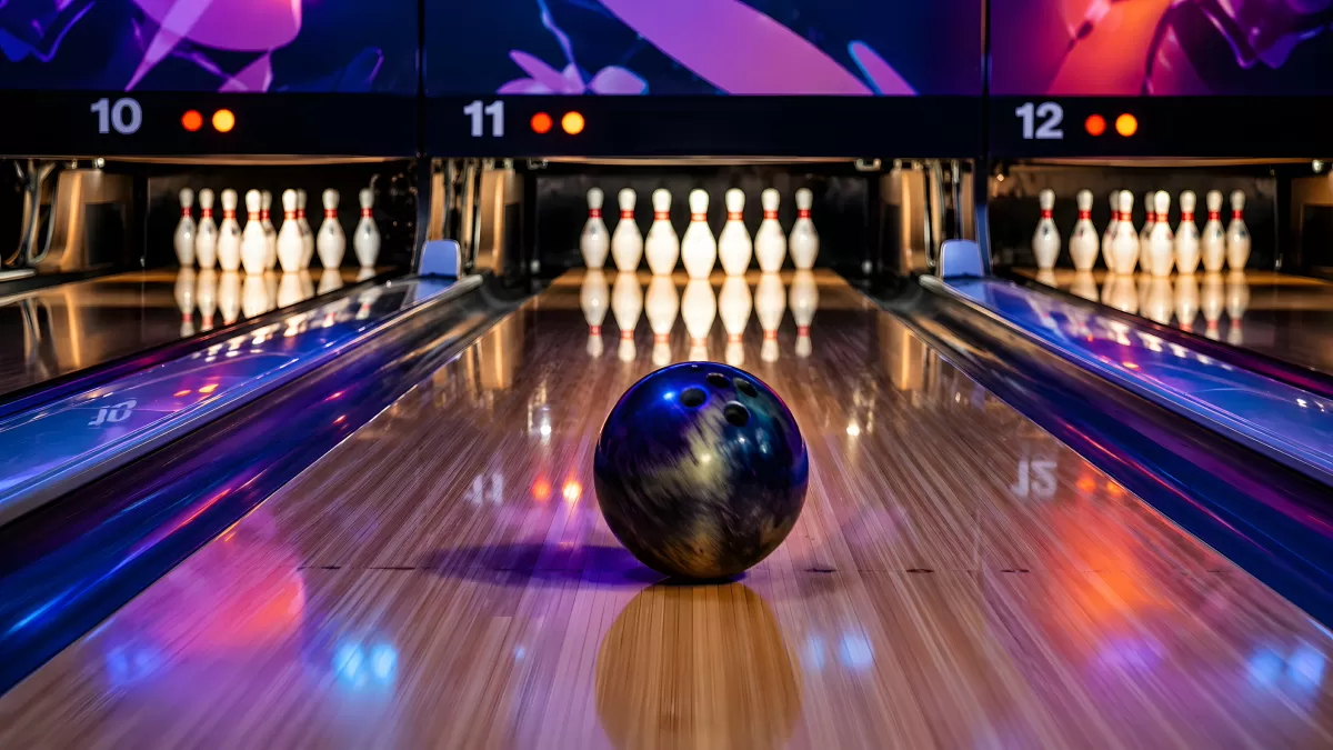 Bowlingkugel rollt auf zehn aufgestellte Pins zu