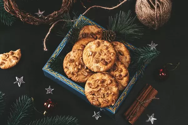 Box of peanut butter cookies in box and Christmas decor on black background (Flip 2019)