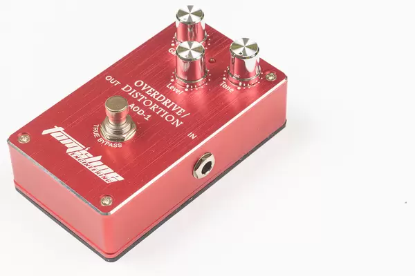Brand new guitar overdrive and distortion pedal above white background