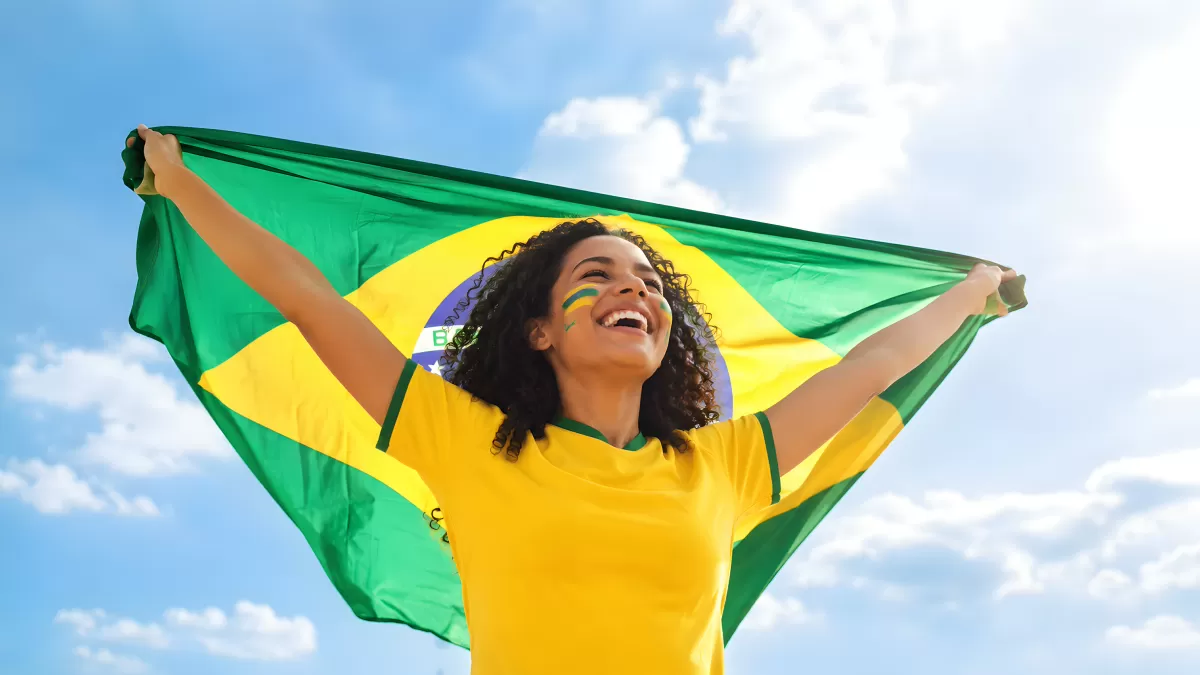 Brasilianische Fußballfan hält Flagge in die Höhe