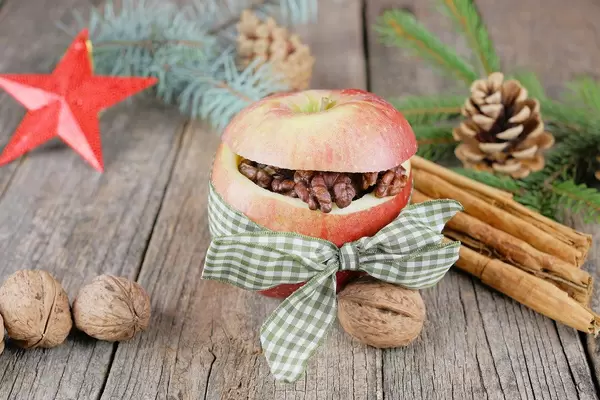 Bratapfel deutsches Rezept umgeben von Nüssen und Zweigen