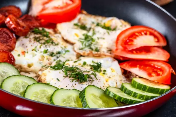 Bratpfanne mit Spiegeleiern, Kräutern und Gemüse