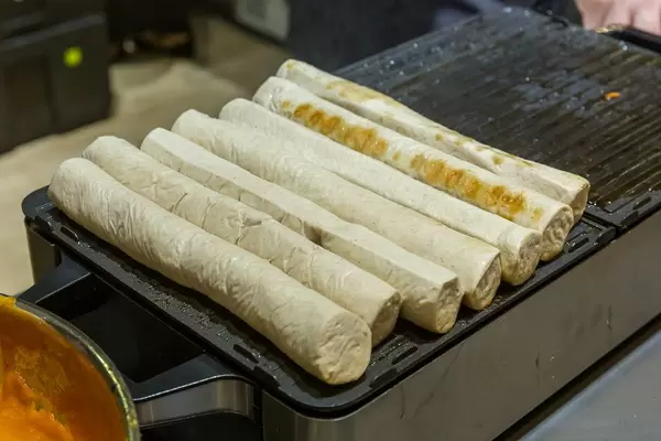 Bratwurst und Currywürstchen auf einer Küchengrillplatte