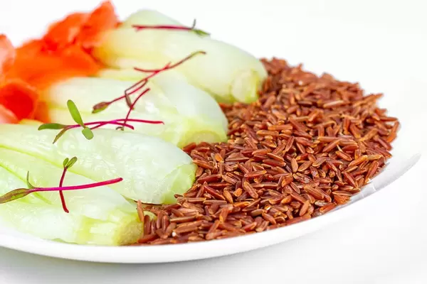 Brauner Reis mit Pak Choi auf einem weißen Teller