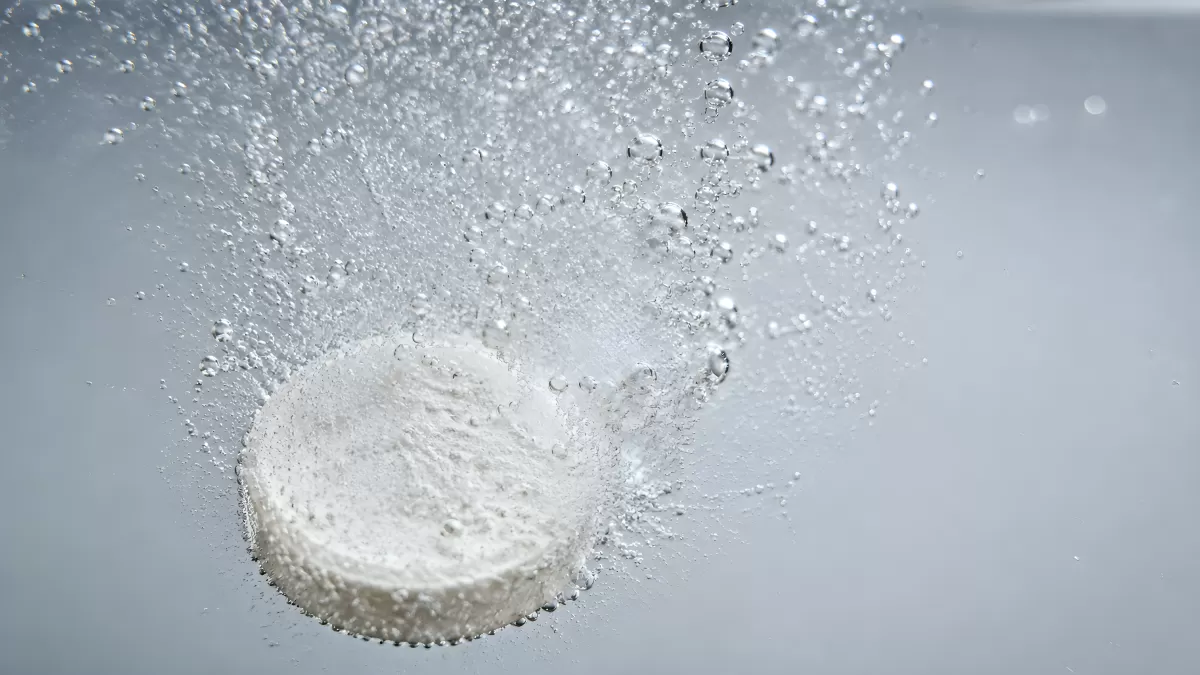 Brausetablette löst sich sprudelnd in Wasser auf