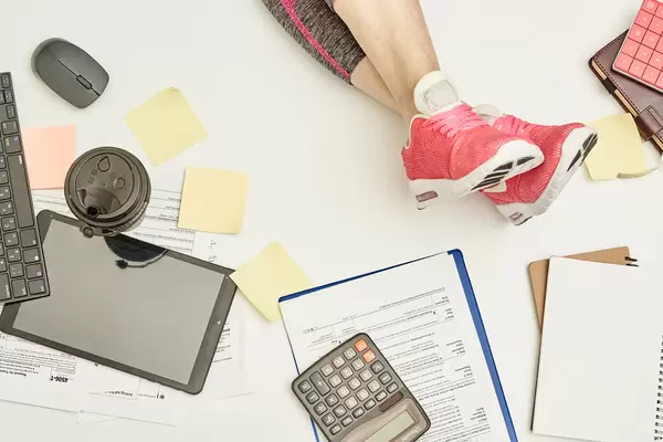 Break time in office. A young lady in fitness clothings resting in the office