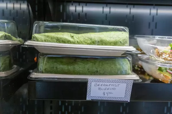 Breakfast Burrito with green tortilla served in a plastic tray to go at For Five Coffee Roasters in Chicago