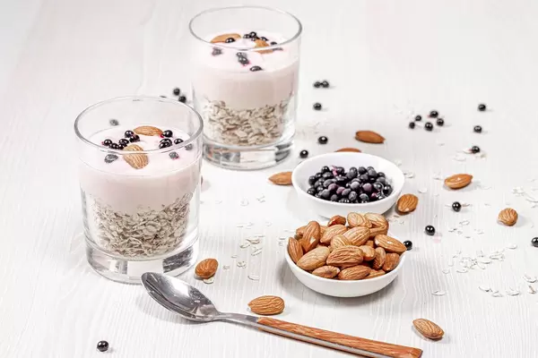 Breakfast concept. Oatmeal with almonds, yogurt and black elderberry (Flip 2019)