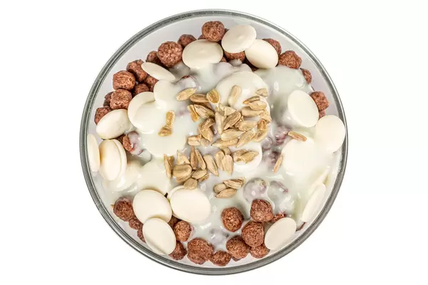 Breakfast with corn balls, chocolate, yogurt and sunflower seeds, top view