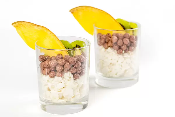 Breakfast with cottage cheese, corn balls, slices of fresh mango and kiwi