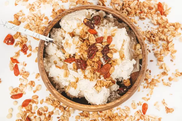 Breakfast with cottage cheese, dried berries and oatmeal on a white background