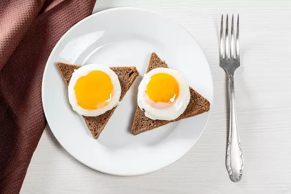 Breakfast with fried eggs and black bread. Top view