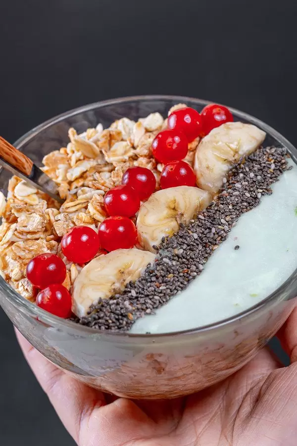 Breakfast with oatmeal and fruit in a glass bowl in a woman's hand (Flip 2019)
