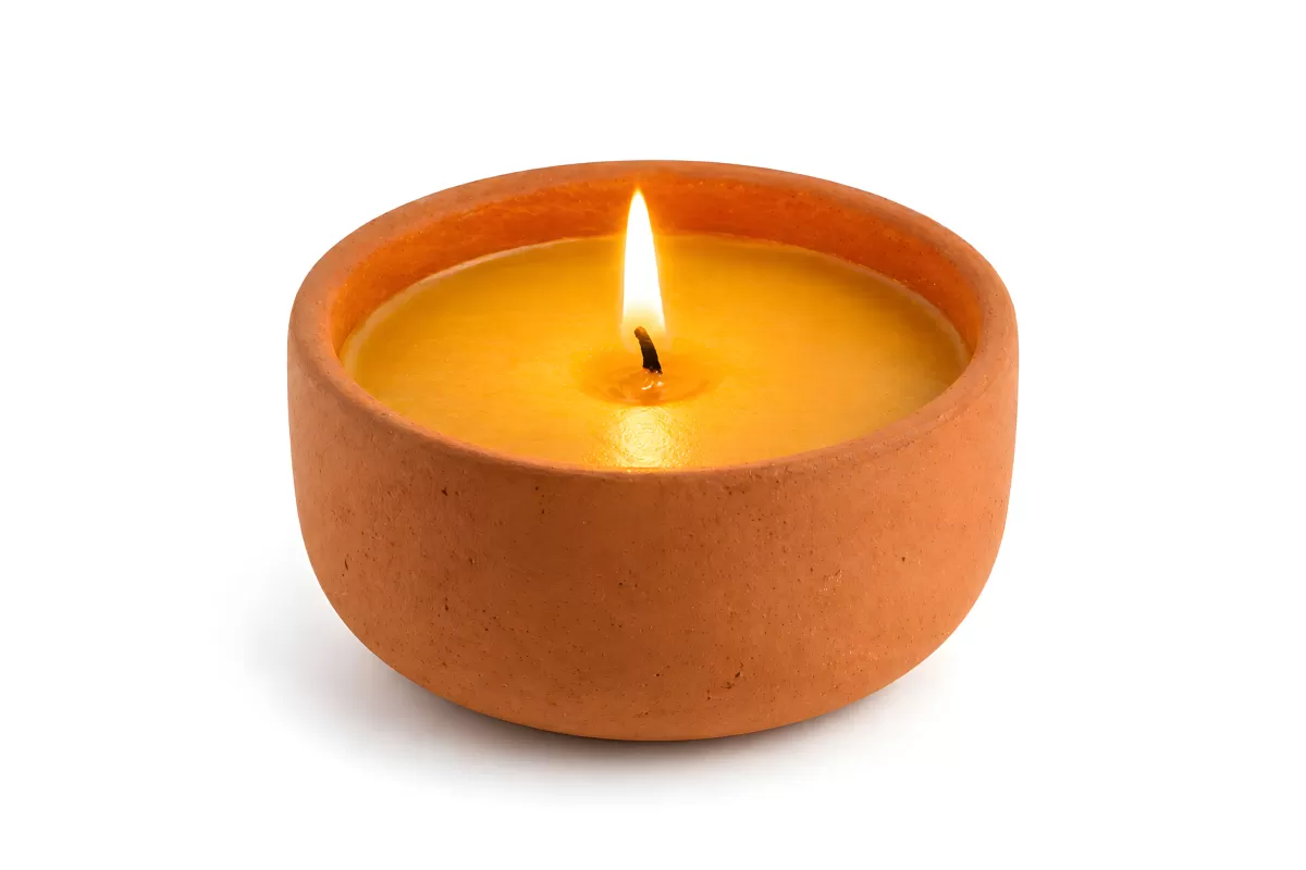 Brennende Kerze in rustikaler Terrakotta-Schale
