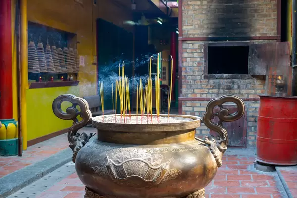 Brennende Räucherstäbchen in einem großen Keramiktopf mit Sand in der chinesischen On Lang Pagode in Distrikt 5 in Ho Chi Minh Stadt, Vietnam