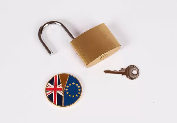 Brexit Medaille mit offenem Vorhängeschloss und Schlüssel vor weißem Hintergrund