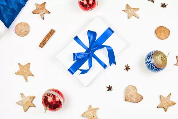 Bright Christmas background with festive cookies, ornaments and present box