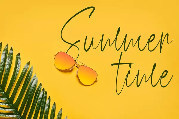 Bright summer background with sunglasses and palm leaf