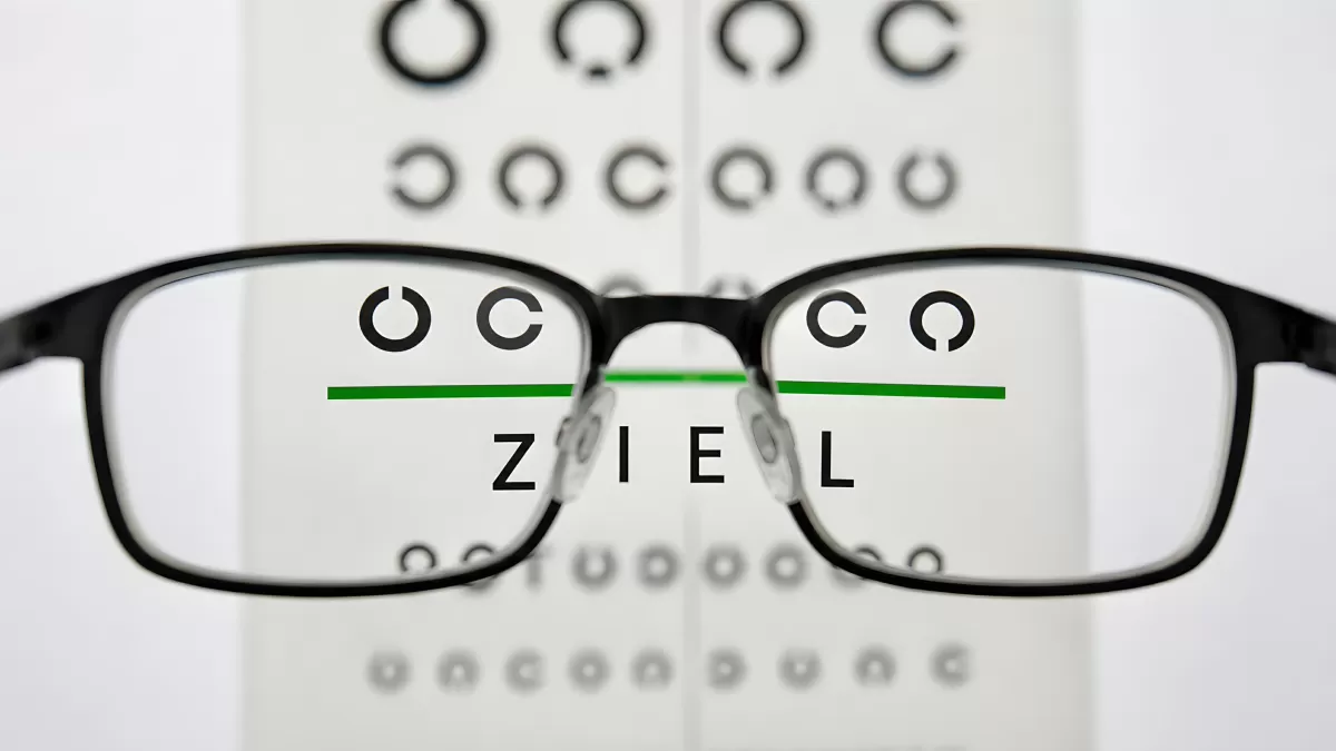 Brille vor Sehtest-Tafel mit deutschem Wort Ziel