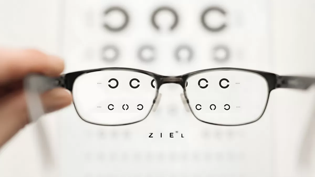 Brille vor Sehtest-Tafel schärft verschwommene Buchstaben