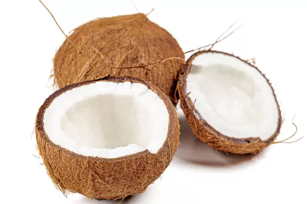 Broken fresh coconut halves and whole coconut on a white background (Flip 2020)