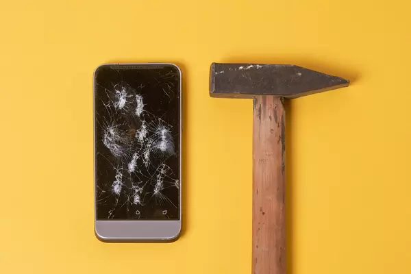 Broken phone and hammer