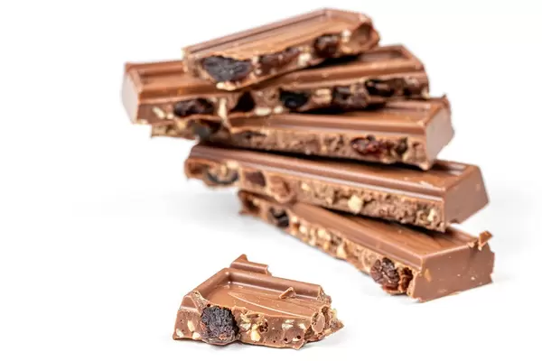 Broken pieces of milk chocolate with nuts and raisins (Flip 2020)