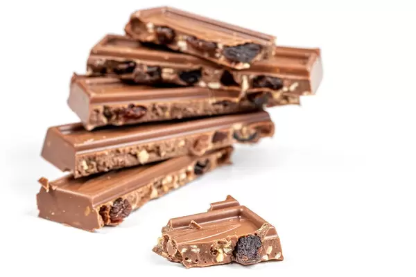 Broken pieces of milk chocolate with nuts and raisins