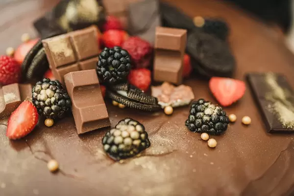 Brombeeren, Schokoladenriegel, Oreokekse und Erdbeeren auf einem Kuchen