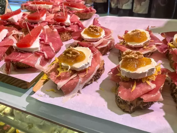 Brot-Häppchen mit Serano Schinken, Weichkäse, Gelee und einer Walnuss