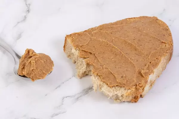 Brot mit Erdnussbutter bestrichen, liegt auf einem Marmortisch