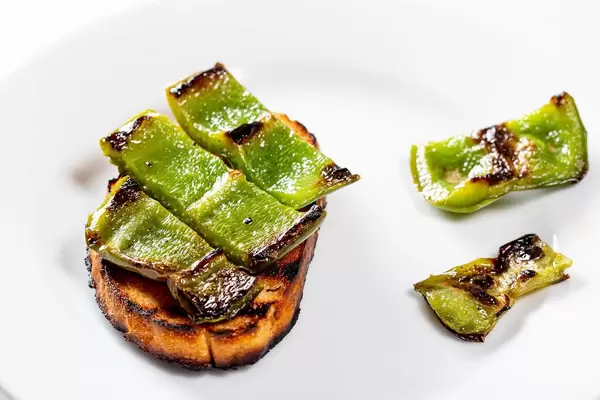 Brot vom Grill, belegt mit grünen Paprikastreifen