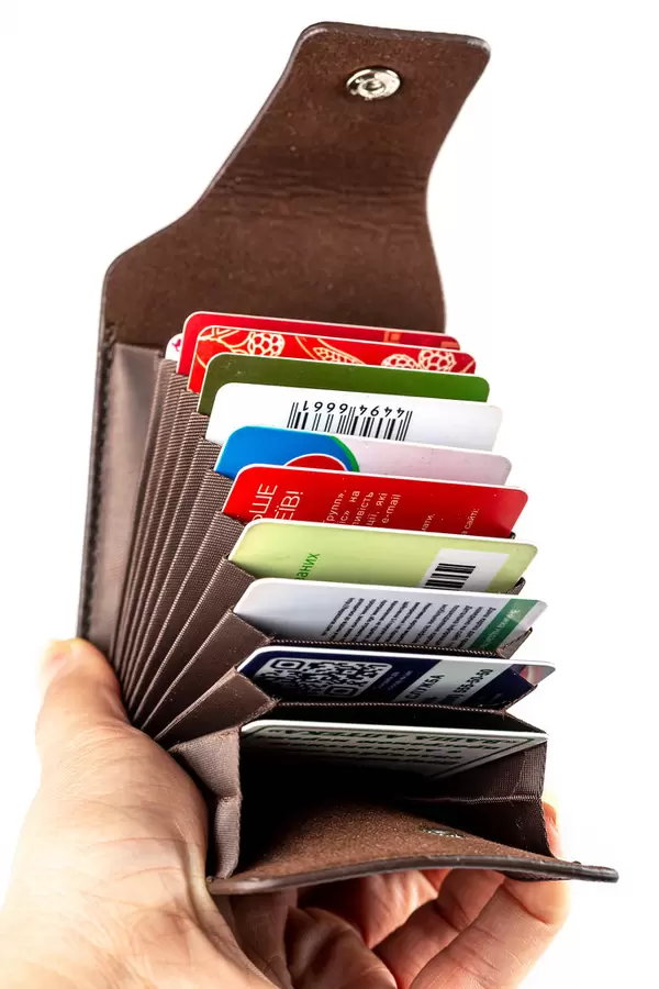 Brown case for cards and business cards in a woman's hand, close-up