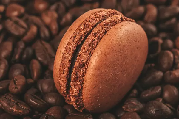 Brown macaroon on a background of coffee beans