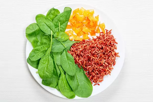 Brown rice with fresh spinach and bell pepper. Top view
