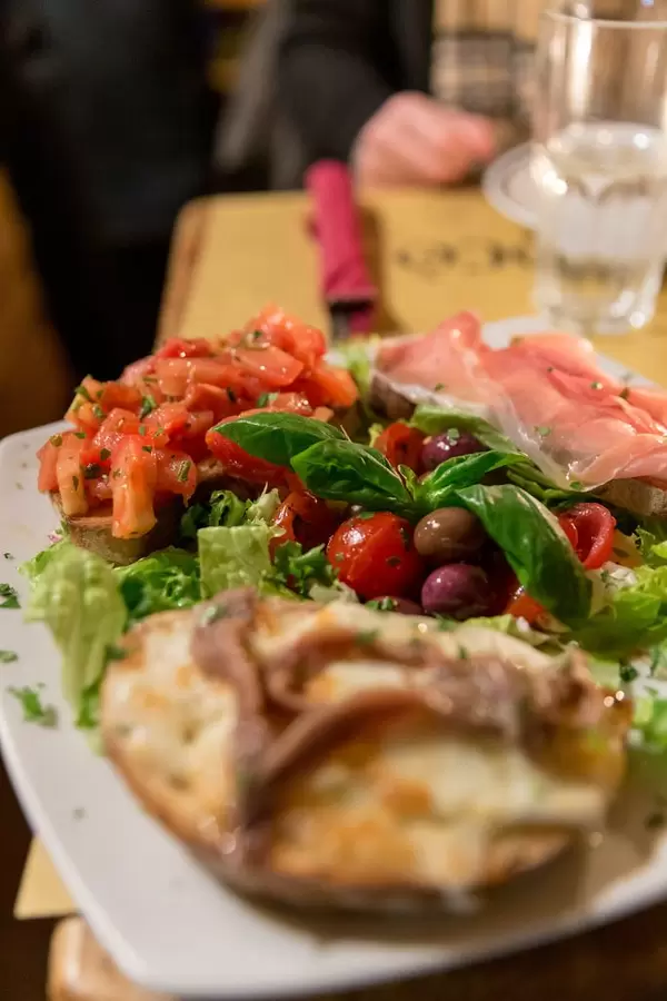Bruschetta with sardines, proscciutto and tomato on salad with olives and basil at Mimi e Coco wine bar in rome